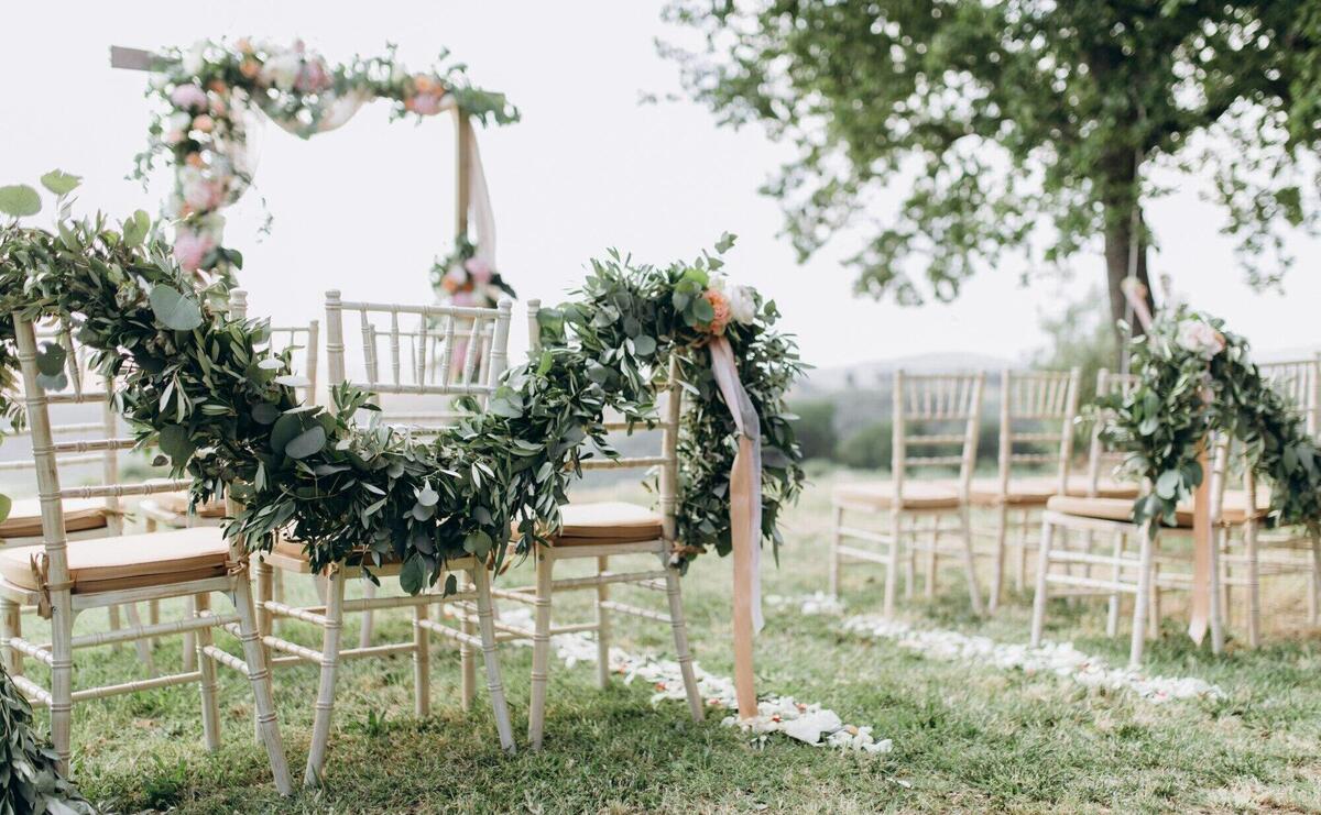 Floral compositions made of greenery at the outdoors wedding ceremony