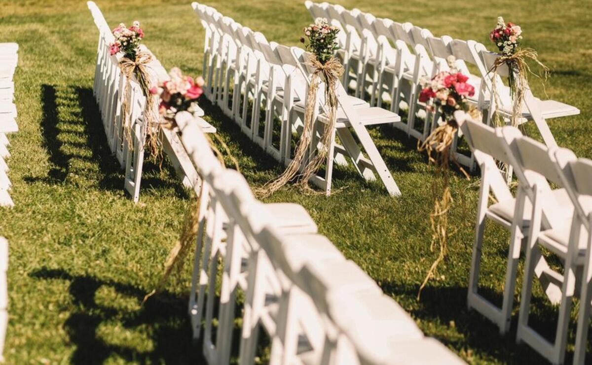 White chairs stand in long rows waiting for the beginning of wedding