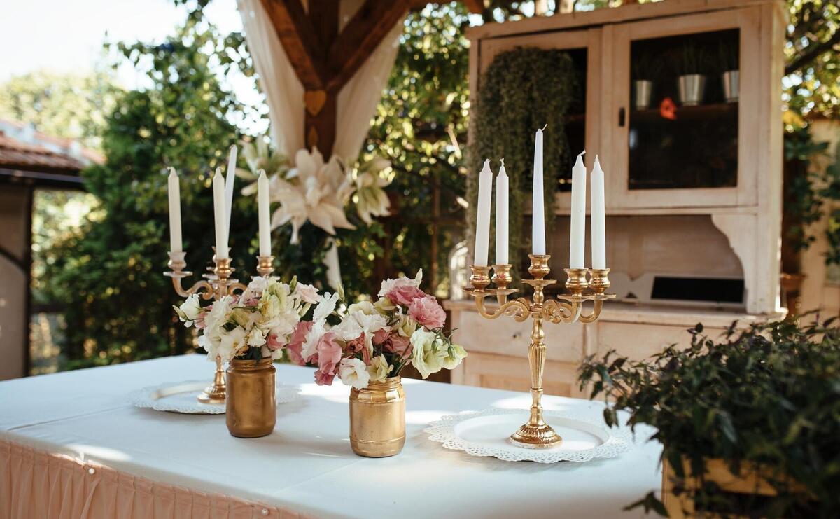 Rustic candlestick and flower arrangement on table at wedding reception.