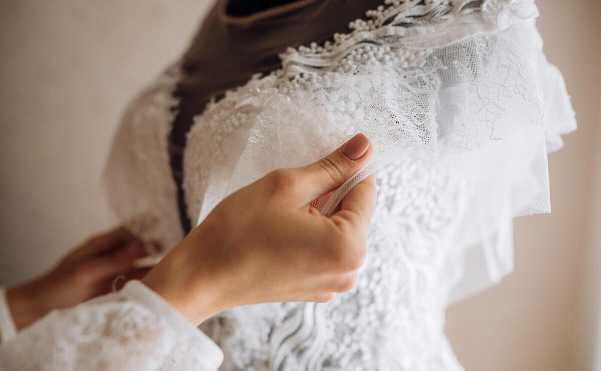 Bride adjusts her bridal dress