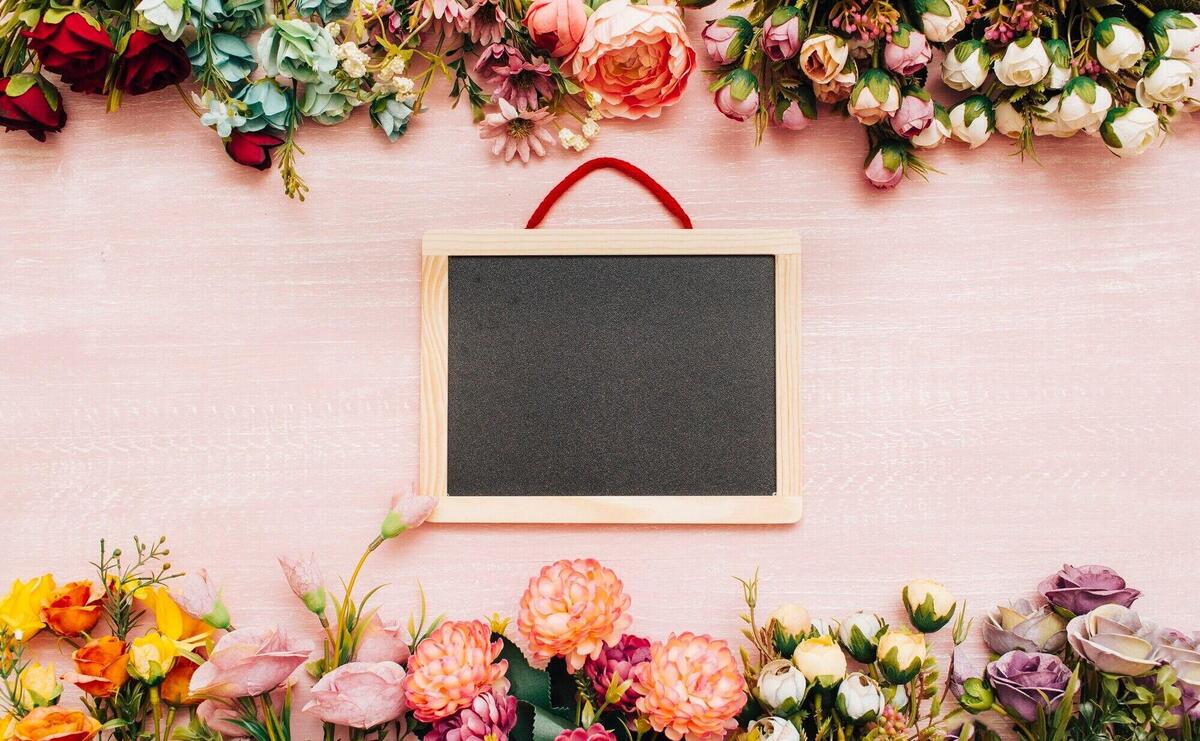 Blackboard on wooden background with flowers